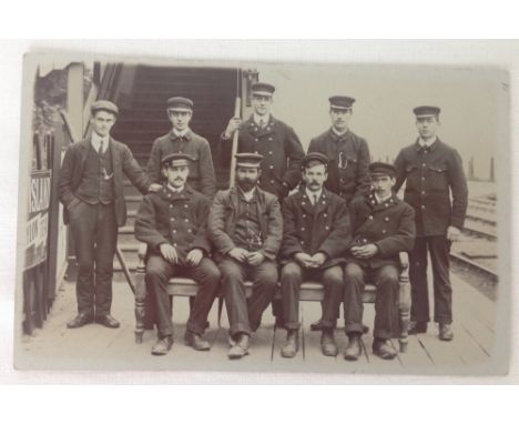 Vintage photographic postcard of a Railway Station master with his staff.