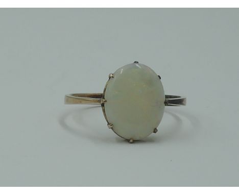 A lady's dress ring having an oval opal in a claw set mount on a rose gold loop tested as 9ct gold,  size M