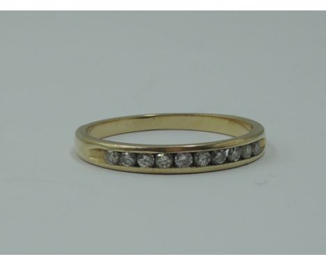 A lady's half eternity ring having ten chanel set diamond chips on a yellow metal loop stamped 14K,  size M