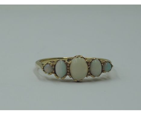 A lady's dress ring having five graduated oval opal cabouchons in a claw set gallery mount on a yellow metal loop stamped 18c