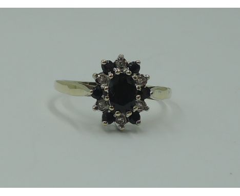 A lady's dress ring having an oval sapphire and diamond chip cluster on a 9ct gold loop, size N