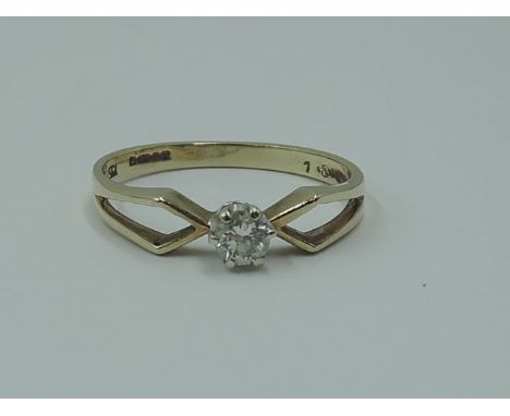 A lady's diamond solitaire dress ring, approx 0.128ct in a claw set mount to open shoulders on a 9ct gold loop,  size N