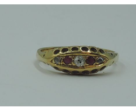 A lady's dress ring having two rubies interspersed by three diamond chips in a gallery mount on a yellow metal loop stamped 1