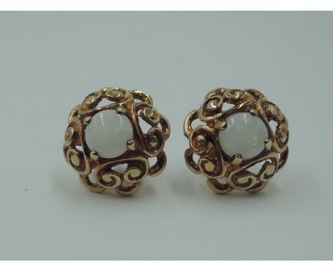 A pair of 9ct gold stud earrings having central opal cabouchons in a shaped pierced mount
stones are approx 5mm diameter. sto