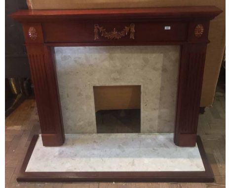 Wooden fire surround with carved foliage together with marble insert and matching hearth and wooden kerb, mantelpiece width 1