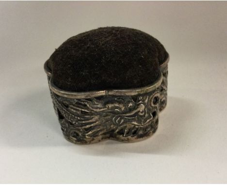 WANG HING: A heavy Chinese silver pin cushion with chased floral decoration. Approx. 25 grams. Est. £200 - £300.