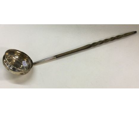 AN early 19th Century silver and whalebone toddy ladle with early inset coin. Approx. 45 grams. Est. £30 - £50.