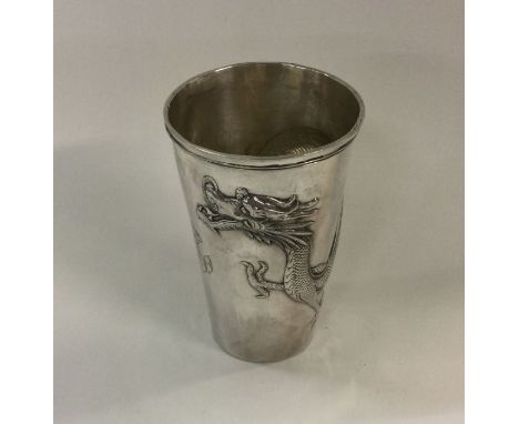 An unusual Chinese silver tapering beaker with dragon decoration. Approx. 82 grams. Est. £150 - £200.