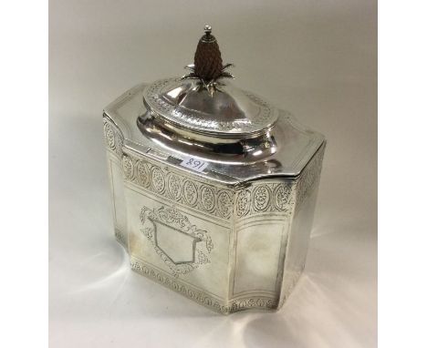 An 18th Century bright cut George III silver tea caddy with pineapple finial of octagonal form and vacant cartouche. London 1