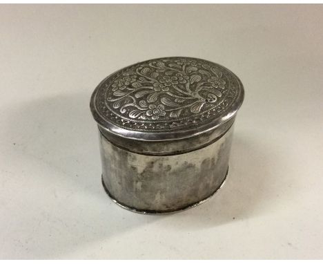 A Chinese silver pill box and cover decorated with flowers and leaves. Approx. 42 grams. Est. £20 - £30.