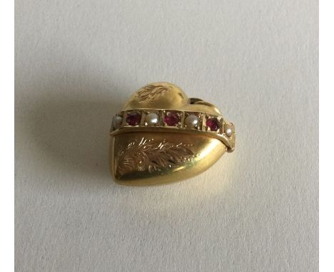 A good Victorian 15 carat gold ruby and pearl heart shaped pendant on chain. Approx. 3 grams. Est. £150 - £250.