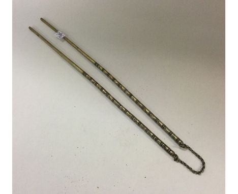 A pair of silver gilt Chinese chop sticks. Approx. 20 grams. Est. £50 - £80.
