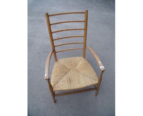 Early 20th C light elm ladder back low rush seated armchair 