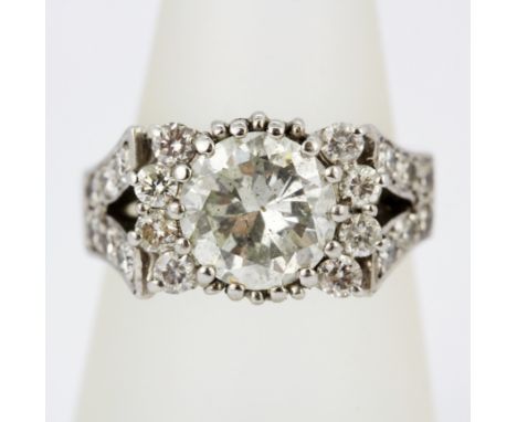 A boxed 18ct white gold (tested) cluster ring set with a large diamond, approx. 2.25ct, surrounded by brilliant cud diamonds 