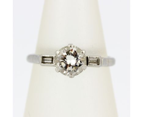 A platinum ring set with a brilliant cut diamond, approx. 0.65ct, with baguette cut diamond set shoulders, (K.5).
