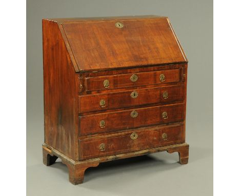 An 18th century walnut veneered bureau, with slope front to fitted interior, with four frieze drawers with brass drop handles