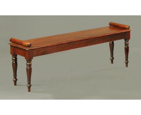 A Victorian style mahogany hall bench or window seat, with bolster ends and raised on turned and fluted legs.  Width 136 cm (