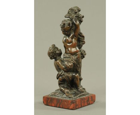 A French bronze group of Pan and Putti, late 19th century, cast as pan tied to a tree stump, Putti at his knees, a lyre and P