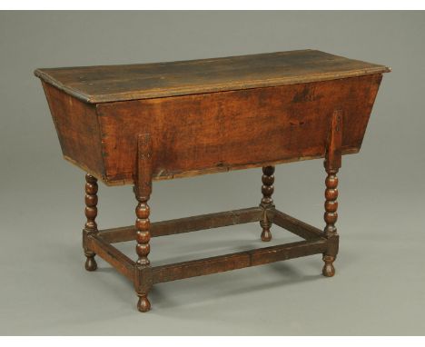 A Georgian oak dough bin, with lift off top and raised on bobbin turned legs with low stretchers.  Width 110 cm. 