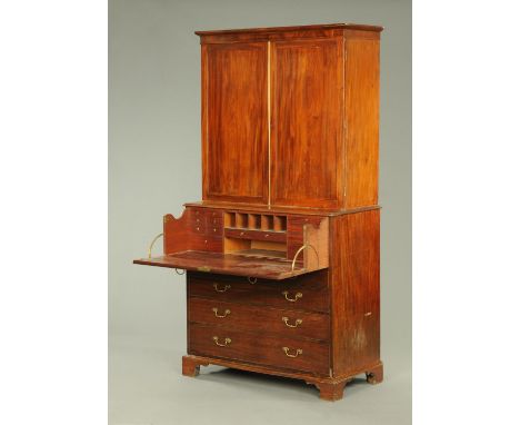 A George III mahogany secretaire linen press, with moulded cornice above a pair of panelled doors with centre brass edging st