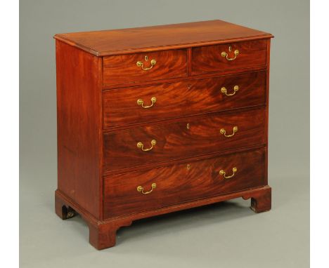 A Georgian mahogany chest of drawers, early 19th century, with well figured top above two short and three long oak lined draw