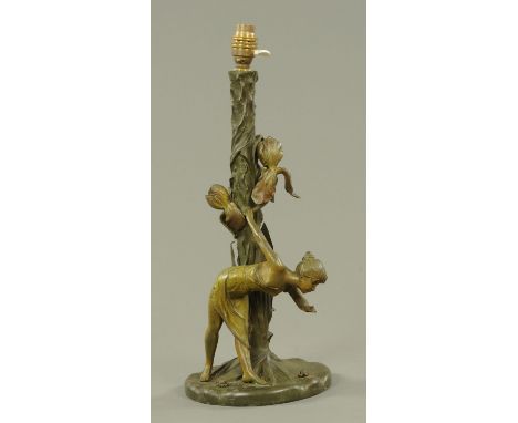 A patinated spelter Art Nouveau period table lamp, late 19th century, cast as a young girl leaning over to inspect her now va