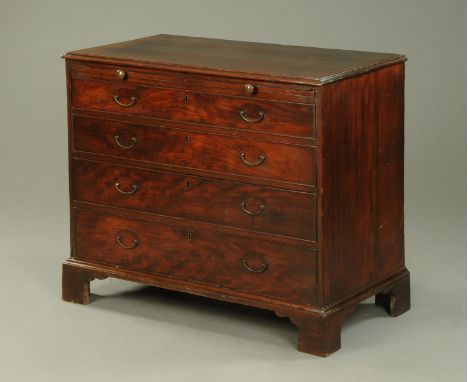 A George III mahogany chest of drawers, with moulded edge above slide and four graduated drawers with brass drop handles and 