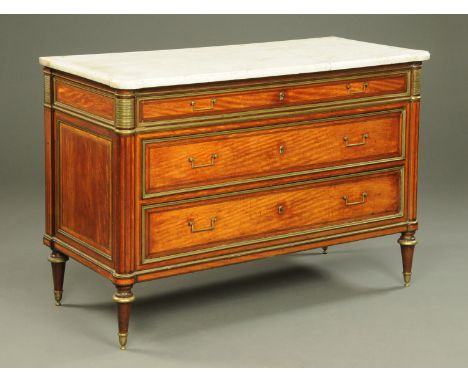 An 18th century satinwood commode, with marble top, fitted with three drawers each with brass drop handles and mounts and rai