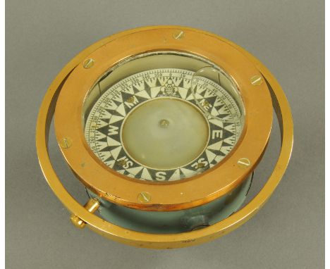 An American marine compass, early 20th century, within a brass case and gimble mount, the dial with manufacturers fleur-de-ly