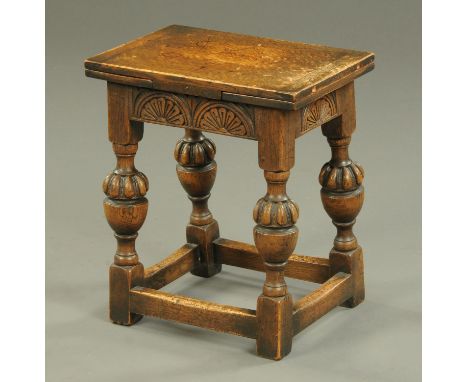 A reproduction oak stool with extending flaps, with cup and cover turned legs.  Width closed 42.5 cm.