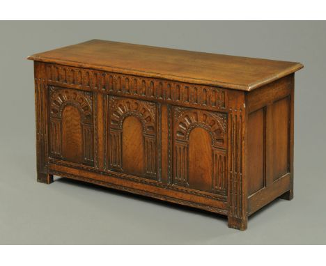 An oak three panelled bedding box, each panel carved with an archway.  Width 117 cm. 