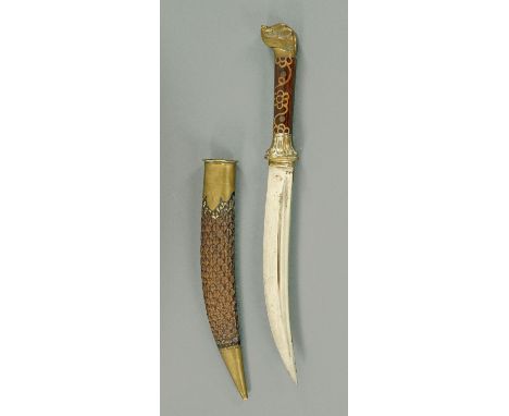 An Eastern dagger, with single fullered curved blade, the wood handle with inlaid decoration and with cast brass mounts, the 