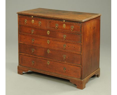 A George III oak chest of drawers, with moulded edge, slide, two short and four long drawers with brass drop handles and rais