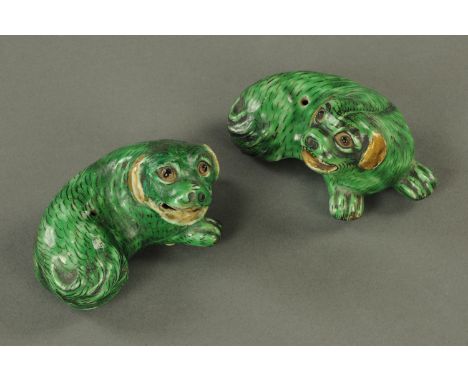 A pair of Chinese incense stick holders, 19th century, modelled as recumbent shi-shi, the eyes and fur picked out in black an