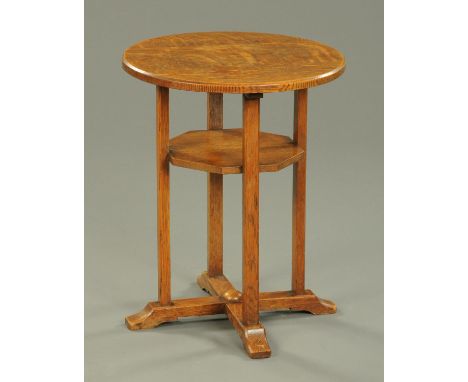 An Arts & Crafts oak two tier side table, with circular top, hexagonal shelf and quatreform base.  Diameter 45.5 cm.    CONDI