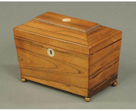 A Regency rosewood tea caddy, raised on short brass feet and with mother of pearl lock escutcheon.  Width 20 cm. 