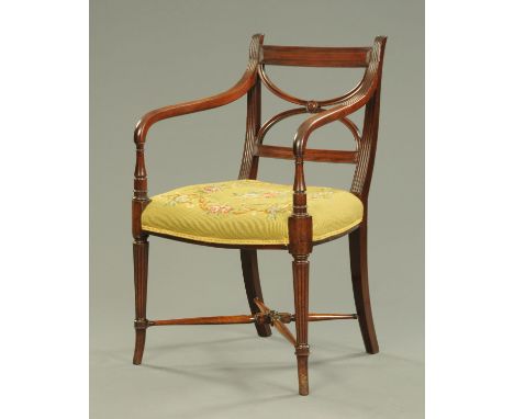 A Regency mahogany armchair, with stuffover seat upholstered in floral tapestry and raised on tapered reeded legs with cross 