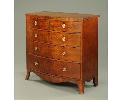 An early 19th century mahogany crossbanded bowfronted chest of drawers, with two short and three long drawers with brass drop