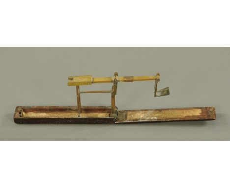 A Wilkinson; a folding guinea balance, late 18th century, with single turn within a mahogany box and with applied paper label