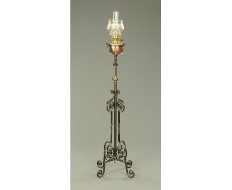 A Victorian oil lamp, with later glass shade and planished copper reservoir, raised on a painted wrought iron stand. 
