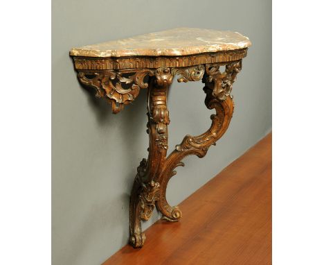 A carved and stained pine Rococo style console table, 19th century, with variegated marble top on S scroll and foliate suppor