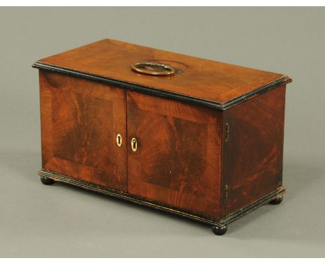 An unusual mahogany tea caddy, early 19th century, rectangular, with crossbanded top and central carrying handle above two cu