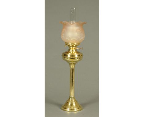 A brass column oil lamp, with pink glass shade and clear chimney.  Overall height 70 cm. 