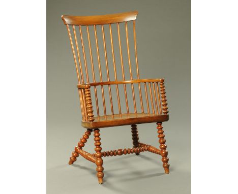 A 19th century mahogany Windsor style armchair, with solid seat and raised on splayed bobbin turned legs (see illustration). 