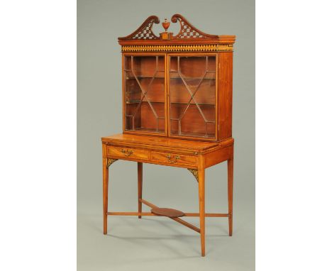 An Edwardian inlaid mahogany cabinet/writing desk, with swans neck pediment, pair of glazed doors, turnover top, two frieze d