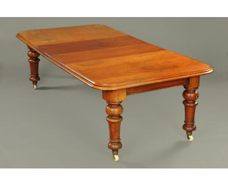 A Victorian mahogany extending dining table, with two leaves, with rounded corners, recessed frieze and raised on four turned