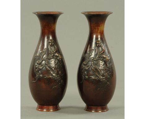 A pair of Japanese bronze vases, Meiji period, cast in relief with an ape clinging on to a leafy branch attached to a rocky o