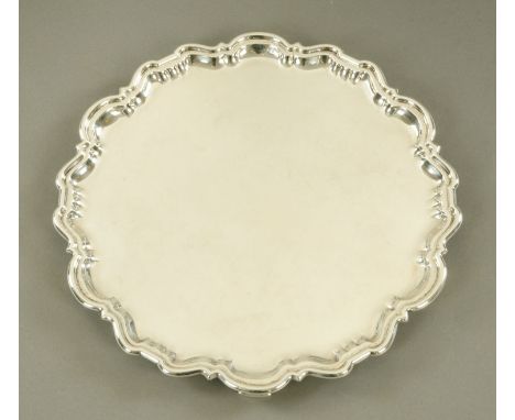 A silver salver, with Chippendale border, raised on bracket feet, Sheffield 1921.  Diameter 35.5 cm, 1091 grams (see illustra