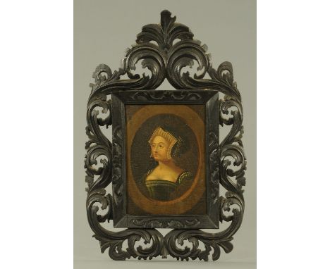 A portrait of a lady in Tudor dress, 19th century, oil on panel.  26.5 cm x 20.5 cm, mounted within a dark stained hand carve