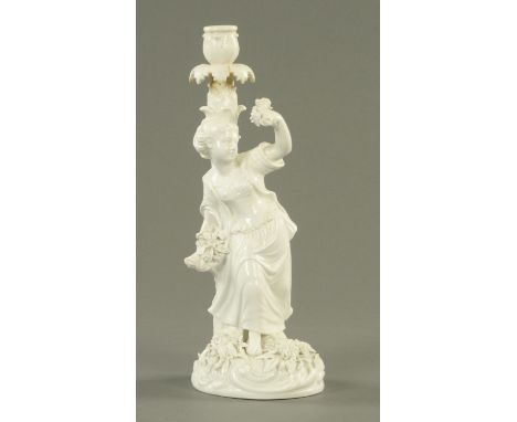 A John Bevington porcelain candlestick, modelled as a female against a leafy trunk, the base applied with flowers above a Roc
